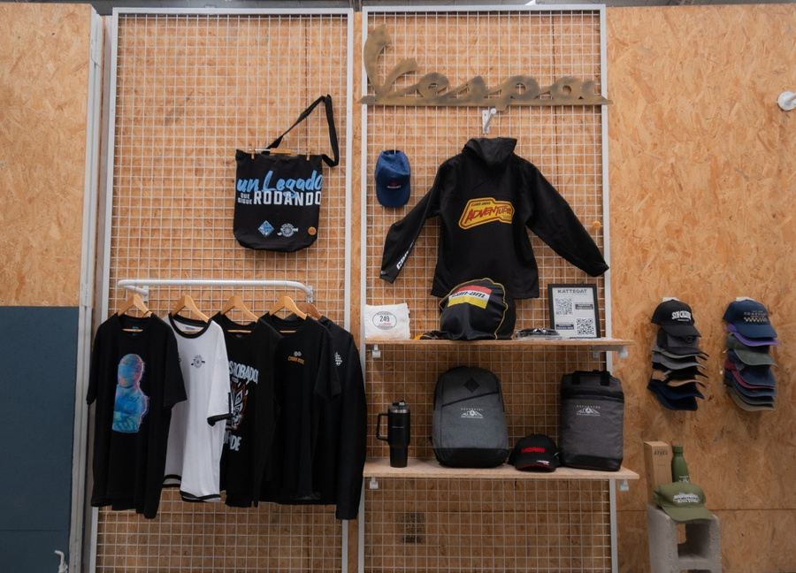 Exhibición de remeras, buzos, gorras y tote bags